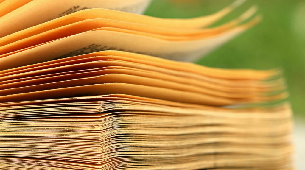 Close-up of book pages in warm orange tones, celebrating human creativity